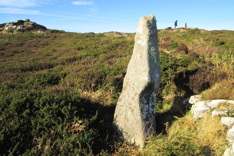 The Watch Croft menhir. My friend is standing on the stony summit cairn on Watch Croft. This menhir is built to be seen from the Nine Maidens and Men an Tol